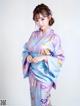 A woman in a blue and purple kimono posing for a picture.