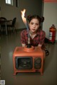 A woman sitting on the floor next to a fire extinguisher.