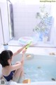 A woman sitting in a bathtub playing with a toy.