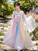 A woman in a colorful hanbok is posing for a picture.