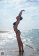 A woman in a blue bikini standing in the ocean.