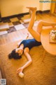 A woman laying on the floor next to a table.