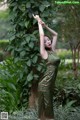 A woman in a green dress holding a baseball bat.