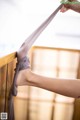 A woman is tying up her legs on a railing.