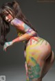 A woman with a body painted in bright colors.