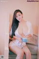 A woman sitting on a stairway holding a cup of coffee.