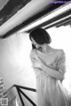 A woman in a white dress standing on a stairwell.