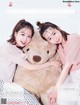 A couple of young women hugging a large teddy bear.