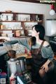 A woman in an apron preparing coffee in a coffee shop.